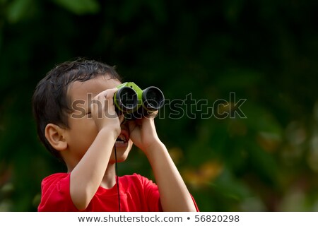 Stockfoto: En · jongen · gebruikt · een · verrekijker · om · een · onderwerp · op · lange · afstand · te · bekijken