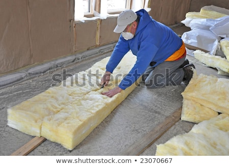 Stockfoto: Man Cutting Insulation Material For Building