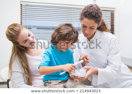 Foto d'archivio: Pediatric Dentist Examining A Little Boys Teeth With His Mother