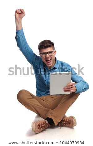 Foto stock: Seated Man Celebrates Good News With Hands In The Air