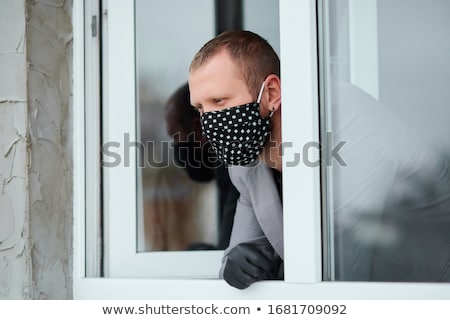 [[stock_photo]]: Man In Black Mask And Medicine Gloves Looking From Window Coronavirus Quarantine