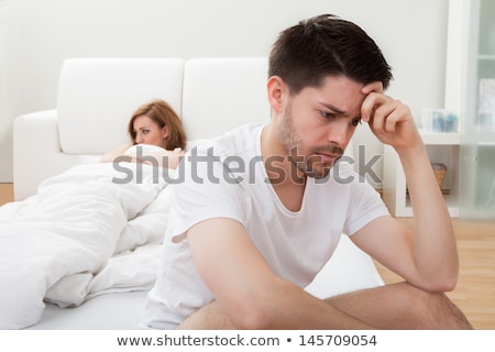 Foto stock: Depressed Man Sitting On The Edge Of The Bed In Bedroom