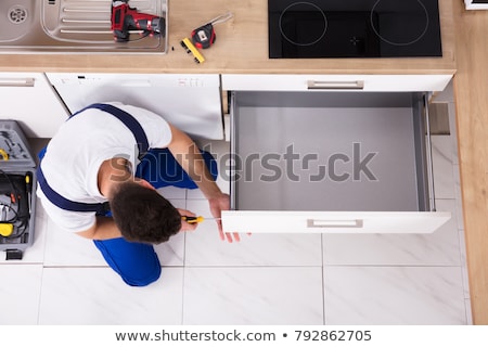 [[stock_photo]]: Male Handyman Installing Drawer