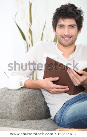 Foto stock: Bachelor Sat On Sofa