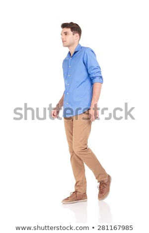 Stockfoto: Side View Of A Smiling Young Casual Man Walking