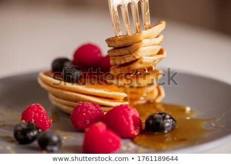 Stok fotoğraf: Raspberry On A Spoon Over A Dessert With Raspberries