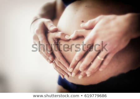 Foto stock: Pregnant Belly With Hands In The Shape Of Hearts