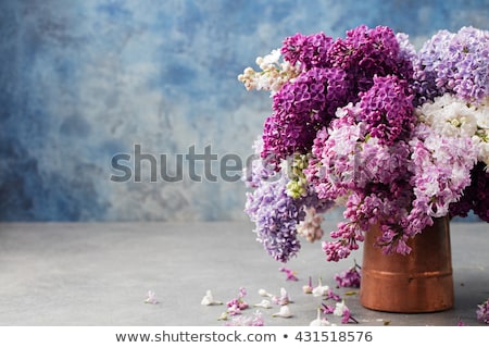 Foto d'archivio: Bunch Of Lilac Flowers In A Cooper Vintage Jug Blue Background Copy Space