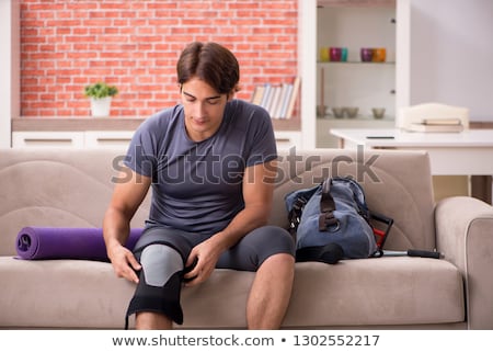 Stockfoto: Young Man With Injured Knee Recovering At Home