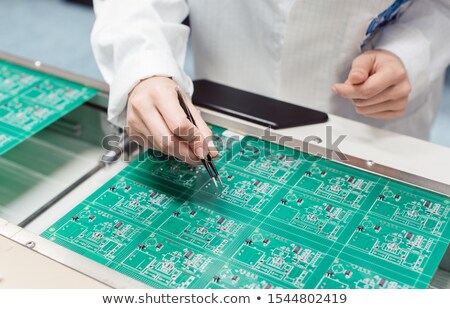 Сток-фото: Technician Assembling Electronic Product By Inserting Components Into Board