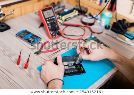 Foto stock: Hands Of Gadget Repairman Fixing Tiny Details Of Demounted Smartphone