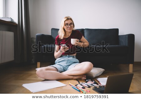 Stockfoto: Young Woman Sitting On Sofa Speaking On Cellphone