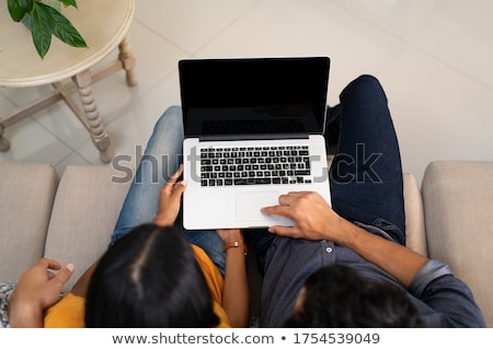 Stockfoto: Hispanic Couple On Black Couch With Computer