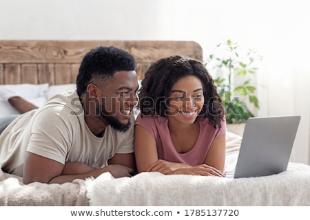 Stock photo: Couple Lying In Bed With Laptop Smiling