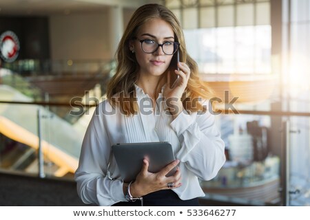 Stock photo: Young Women Use Escalators And Using A Mobile Phone