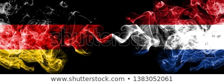 [[stock_photo]]: Two Waving Flags Of Germany And Netherlands