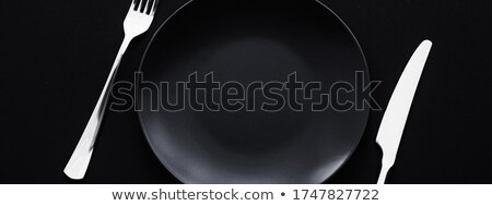 Foto d'archivio: Empty Plates And Silverware On Black Background Premium Tableware For Holiday Dinner Minimalistic