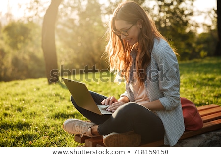 Stock fotó: Young Pretty Woman With Laptop Sitting On The Bench In A Park