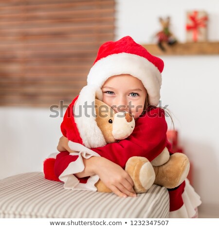 Stockfoto: Young Girl And Soft Toy Wearing Santa Hats