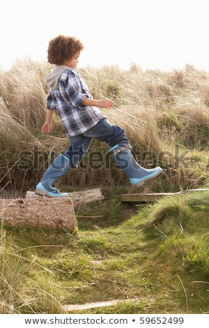 Stock fotó: Young Boy Putting On Wellington Boots