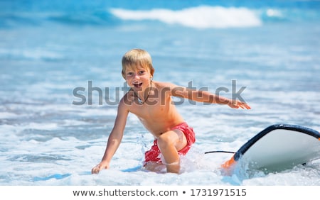 Сток-фото: Boy Has Fun Running With Surfboard In The Waves