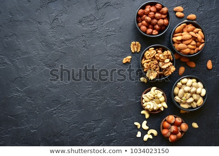 Foto stock: Different Nuts On Dark Stone Table Hazelnut Walnuts