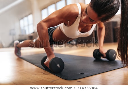 Stock fotó: Gym Woman Doing Pushup Exercise With Dumbbell In A Gym