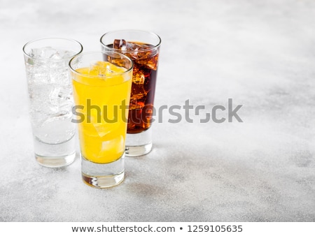 Сток-фото: Glasses Of Soda Drink With Ice Cubes And Bubbles On Stone Kitchen Table Background Cola And Orange