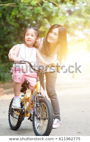 Мать с дочерью на велосипеде в весеннем саду Сток-фото © szefei