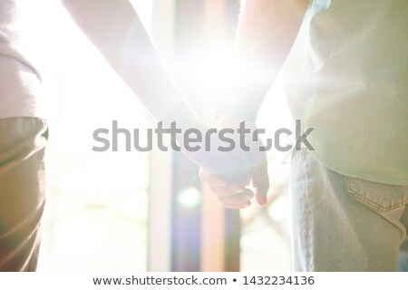 Foto stock: Flare Of Sunlight Between Hands Of Casual Senior Spouses