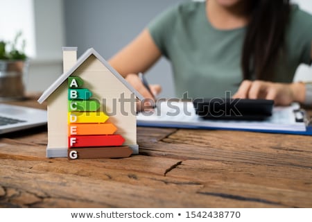 Foto stock: Woman Calculating Energy Efficient House