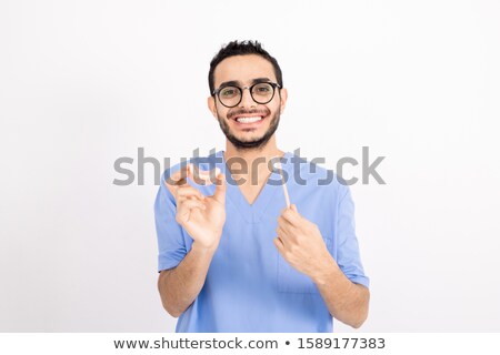 Foto stock: Contemporary Dentist In Blue Uniform Showing You False Teeth And Toothbrush