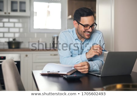 Stock fotó: Man Using A Laptop In His Kitchen