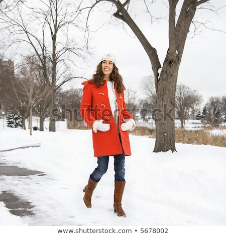 Foto stock: Young Woman Walking Down Snow Covered Street