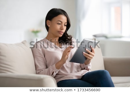 Foto stock: Beautiful African American Woman Reading A Tablet