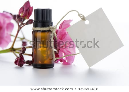 Stock foto: Bottle With Essence Oil And Pink Flowers Isolated On White