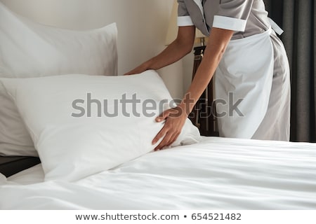 [[stock_photo]]: Cropped Image Of A Chambermaid Making Bed In Hotel Room