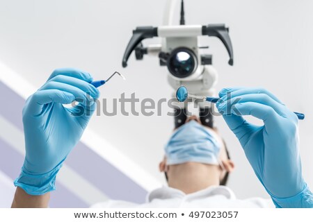 Foto stock: Male Dentist Using Dental Tools