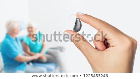 Stock photo: Woman Holding Hearing Aid