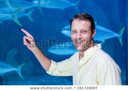 Stockfoto: Man Looks At The Fish In The Aquarium