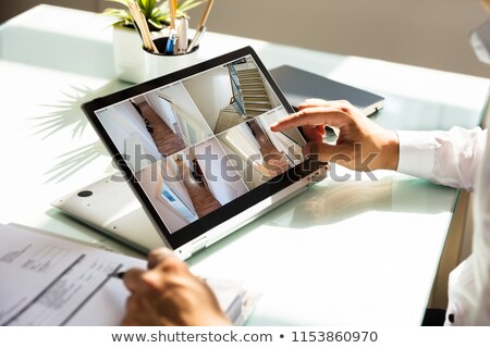 Stockfoto: Businessman Checking Cctv Camera Footage On Laptop