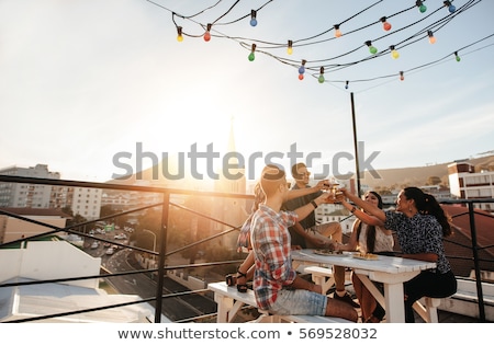 ストックフォト: Happy Friends Toasting Drinks At Rooftop Party