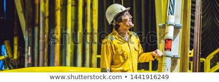 Foto stock: Banner Long Format Young Man In A Yellow Work Uniform Glasses And Helmet In Industrial Environment