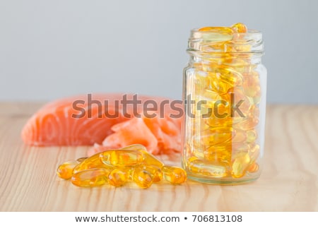 Stock photo: Fish Oil Capsules On Fresh Wild Red Salmon