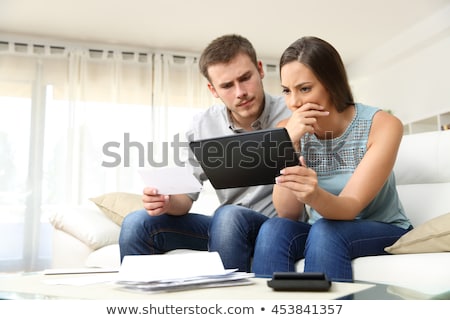 ストックフォト: Man Checking Bills On The Tablet At Home