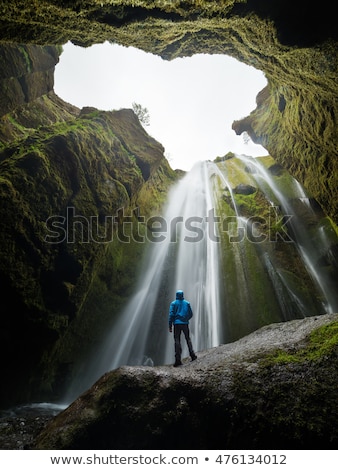 Сток-фото: Tourist Looks At The Big Waterfall In Iceland