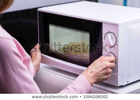 Stock fotó: Woman Adjusting Temperature Of Microwave Oven