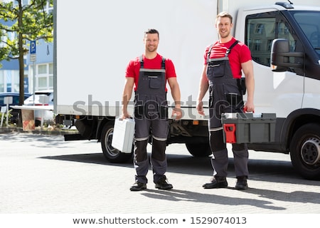 Foto d'archivio: Portrait Of A Smiling Young Male Technicians Holding Tool Box