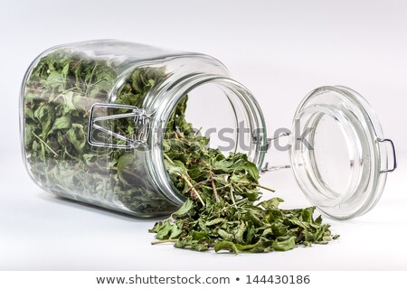 Stock photo: Glass Container With A Tea Leaf Spilled On Table