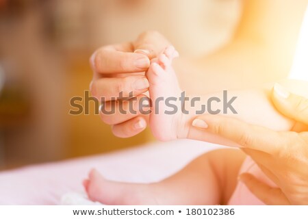 Baby With Mother She Is Holding Her Feet Stockfoto © Kzenon